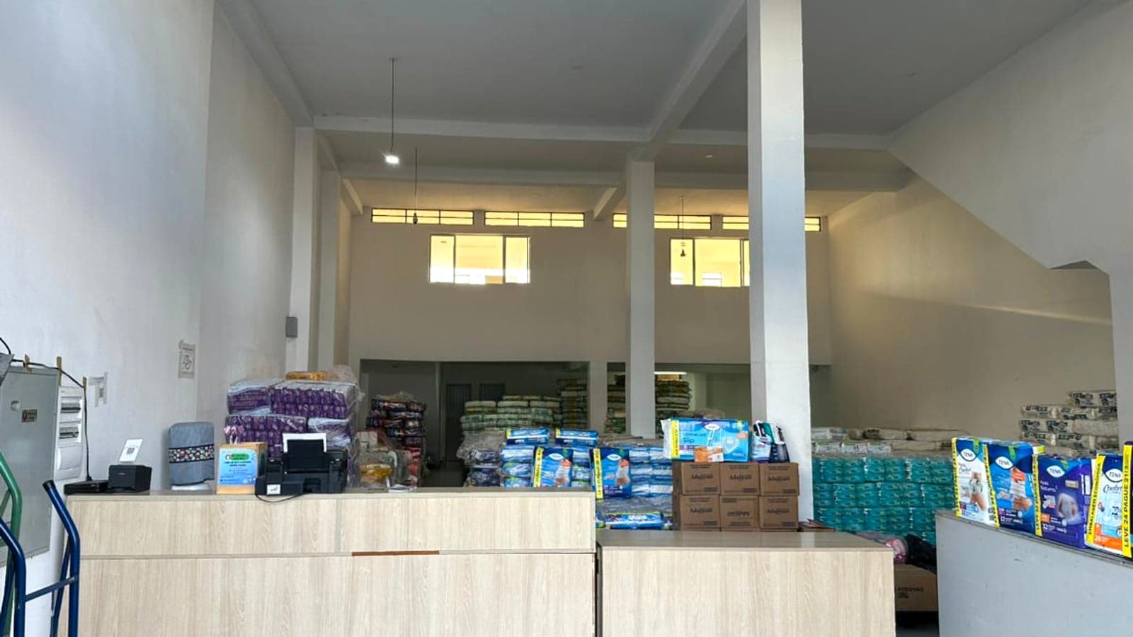 Interior da Copamar Fraldas em Santo André/SP: balcão de atendimento e estoque de fraldas geriátricas (Tena, Adultcare) ao fundo